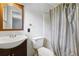 A bathroom with a dark wood vanity, toilet, and a shower with a striped curtain at 2415 Wales Dr, Austell, GA 30106