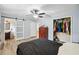 This bedroom includes a sliding door bathroom access, wood dresser, and closet with hanging clothes at 2415 Wales Dr, Austell, GA 30106