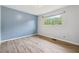 This bedroom offers ample light from the window, neutral walls, and updated flooring at 2415 Wales Dr, Austell, GA 30106