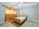 This bedroom features wood-look flooring, a simple rattan bed frame, and vintage-style curtains at 2415 Wales Dr, Austell, GA 30106