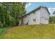 Side exterior view of a two-story home showcasing the yard, siding, windows, and a brick chimney at 2415 Wales Dr, Austell, GA 30106