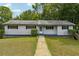 Charming single-story home with a well-manicured lawn, complemented by mature trees and lush greenery at 2415 Wales Dr, Austell, GA 30106