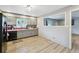 This kitchen offers cabinets with an adjacent view into another room, a tiled backsplash, and wood-style flooring at 2415 Wales Dr, Austell, GA 30106
