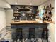 Basement wet bar with black brick, wooden countertop, shelving and polished concrete floor at 410 Spring Lake Hls, Canton, GA 30114