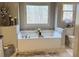Bathroom with garden tub, tile backsplash, and window view at 410 Spring Lake Hls, Canton, GA 30114