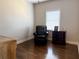 Cozy bedroom showcasing hardwood floors, natural light from the window, chair and a dresser at 410 Spring Lake Hls, Canton, GA 30114