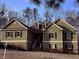 Charming two-story home with green siding, black shutters, dormer windows and landscaped yard at 410 Spring Lake Hls, Canton, GA 30114