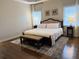 Main bedroom with bed, neutral colored walls, side tables, lamps, and light from window at 410 Spring Lake Hls, Canton, GA 30114