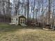 Backyard shed with double doors, ramp, and windows with green lawn and wooded area beyond at 410 Spring Lake Hls, Canton, GA 30114