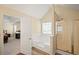 Bright bathroom features a soaking tub, separate shower, and an open doorway to the primary bedroom at 63 Shadowhill Ct, Loganville, GA 30052