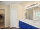 Bright bathroom features a double sink vanity with blue cabinets, large mirror, and separate tub and shower at 63 Shadowhill Ct, Loganville, GA 30052
