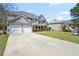 Exterior view of home with a large driveway, showcasing curb appeal and landscaping at 63 Shadowhill Ct, Loganville, GA 30052