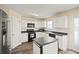 Kitchen area with white cabinets and an island with black countertops and stainless steel appliances at 63 Shadowhill Ct, Loganville, GA 30052