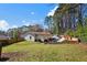Large grassy backyard with a patio area featuring an outdoor umbrella, mature trees, and privacy fencing at 3776 Bromolow Trl, Lawrenceville, GA 30044