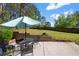 Cozy backyard patio with an umbrella, seating area, and a well-maintained lawn with mature trees at 3776 Bromolow Trl, Lawrenceville, GA 30044