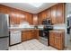 Charming kitchen with wood cabinetry, stainless steel appliances, and ample counter space at 3776 Bromolow Trl, Lawrenceville, GA 30044