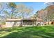 Expansive backyard featuring a screened-in patio, lush green grass, and mature trees at 5095 Derry Nw Rd, Acworth, GA 30101