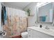 Clean bathroom with a white vanity, decorative shower curtain, and ample lighting at 5095 Derry Nw Rd, Acworth, GA 30101