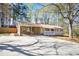 A charming single-story home with a covered carport and porch, surrounded by mature trees and an expansive front yard at 5095 Derry Nw Rd, Acworth, GA 30101