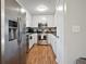 Galley kitchen featuring stainless steel appliances, white cabinets, and durable laminate flooring for modern convenience at 5095 Derry Nw Rd, Acworth, GA 30101