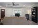 Neutral living room featuring plush carpet, a comfortable sofa, entertainment center, a book shelf and a large sunny window at 5095 Derry Nw Rd, Acworth, GA 30101