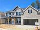 Charming two-story home featuring gray brick, black shutters, and an attached two-car garage at 2664 Mourning Dove Drive( Lot 38), Grayson, GA 30017