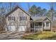 Charming two-story home with a front porch and a two-car garage and tan siding and shutters at 321 Oak Landing Cir, Douglasville, GA 30134