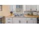 Well-maintained kitchen features white cabinets, wood countertop, undermount sink, and tiled backsplash at 321 Oak Landing Cir, Douglasville, GA 30134