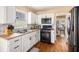 The kitchen has white cabinets, stainless appliances, hardwood floors, and a view of the dining area at 321 Oak Landing Cir, Douglasville, GA 30134