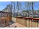 Backyard with a wooden deck, grass, trees and a fence at 657 Kenridge Dr, Suwanee, GA 30024