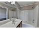 Well-lit bathroom features a tub-shower combo with white tile surround and vanity with sink at 657 Kenridge Dr, Suwanee, GA 30024