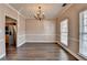 Well-lit dining room featuring hardwood floors, crown molding, and a chandelier, plus access to kitchen at 657 Kenridge Dr, Suwanee, GA 30024