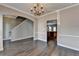 Dining room featuring wood floors, chandelier, and arched doorway to the kitchen at 657 Kenridge Dr, Suwanee, GA 30024