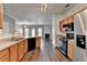 Open concept kitchen with stainless steel appliances, breakfast bar, and view to the living room at 657 Kenridge Dr, Suwanee, GA 30024