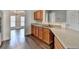 Modern kitchen area featuring light wood cabinets, hardwood floors, stainless steel dishwasher and sink at 657 Kenridge Dr, Suwanee, GA 30024