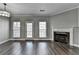 Spacious living room featuring hardwood floors, a fireplace and natural light from the large windows at 657 Kenridge Dr, Suwanee, GA 30024