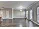 Spacious living room featuring wood floors, large windows, and modern lighting fixture at 657 Kenridge Dr, Suwanee, GA 30024