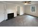 This bedroom has a fireplace, window, ceiling fan, carpet and entry to another room at 121 Northwoods Rd, Sharpsburg, GA 30277