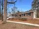 Brick home exterior featuring a welcoming porch and a well-maintained yard at 121 Northwoods Rd, Sharpsburg, GA 30277