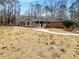 Inviting rear view of the home, showcasing a spacious yard and a serene, wooded backdrop, ready for relaxation and outdoor enjoyment at 121 Northwoods Rd, Sharpsburg, GA 30277