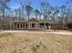 A beautiful ranch-style home features large windows, brick accents and a cozy porch with a sprawling lawn at 121 Northwoods Rd, Sharpsburg, GA 30277