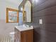 Updated bathroom features a wood vanity, black accent wall, and updated mirror and fixtures at 1312 Milstead Ave, Conyers, GA 30012