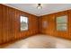 Bedroom features knotty pine wood paneling, hardwood floors, and natural light at 1312 Milstead Ave, Conyers, GA 30012