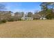View of front exterior with large front yard, and mature trees at 1312 Milstead Ave, Conyers, GA 30012