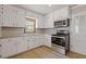 Modern kitchen with white cabinets, stainless steel appliances, and tile backsplash at 1312 Milstead Ave, Conyers, GA 30012