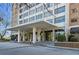 Exterior view of the building entrance featuring a covered driveway, stone columns, and glass doors at 215 Piedmont Ne Ave # 2205, Atlanta, GA 30308