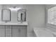 Bathroom featuring a double sink vanity, framed mirrors, and a luxurious soaking tub at 4654 Webster Way, Acworth, GA 30101