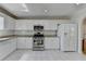 A well-lit kitchen featuring granite countertops, stainless steel appliances, and white cabinets at 4654 Webster Way, Acworth, GA 30101