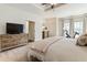 Bright main bedroom with a ceiling fan, a TV on a wooden dresser, and a Peloton exercise bike at 625 Aunt Lucy Sw Ln # 29, Smyrna, GA 30082