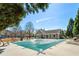 Pool area with a green safety cover, surrounded by lounge chairs and privacy landscaping, and clubhouse in background at 625 Aunt Lucy Sw Ln # 29, Smyrna, GA 30082